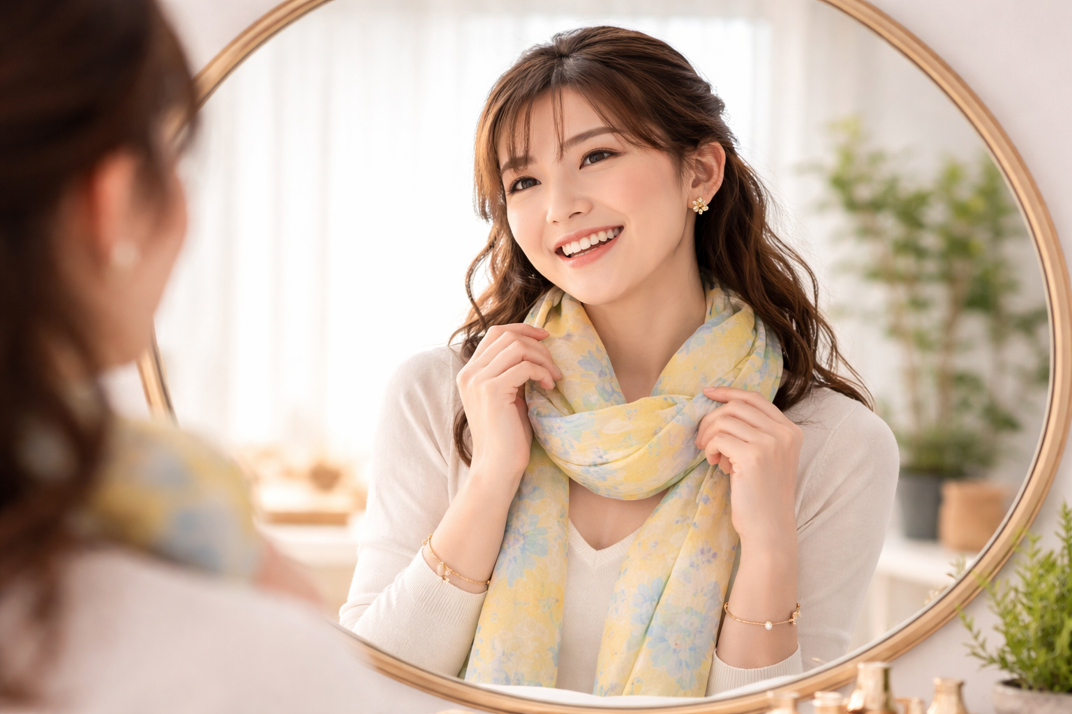 鏡の前で、新しい明るい色のストールやアクセサリーを身に着け、晴れやかな笑顔で自分を見つめる女性